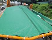 A green tarp over a truck

Description automatically generated with low confidence